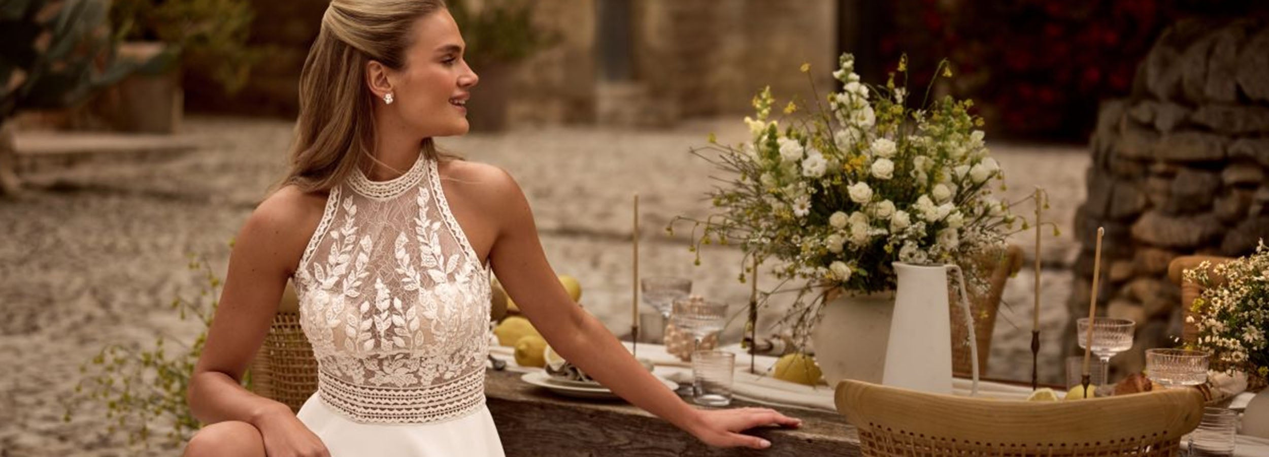 Robe de mariée bohème en dentelle avec col haut, coupe fluide et style romantique, parfaite pour un mariage champêtre ou en plein air.