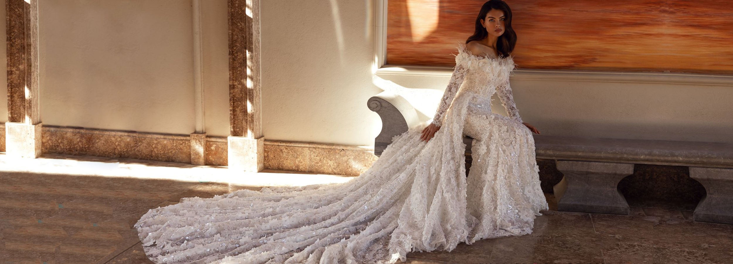Robe de mariée sirène en dentelle florale avec manches longues, épaules dénudées et longue traîne élégante.
