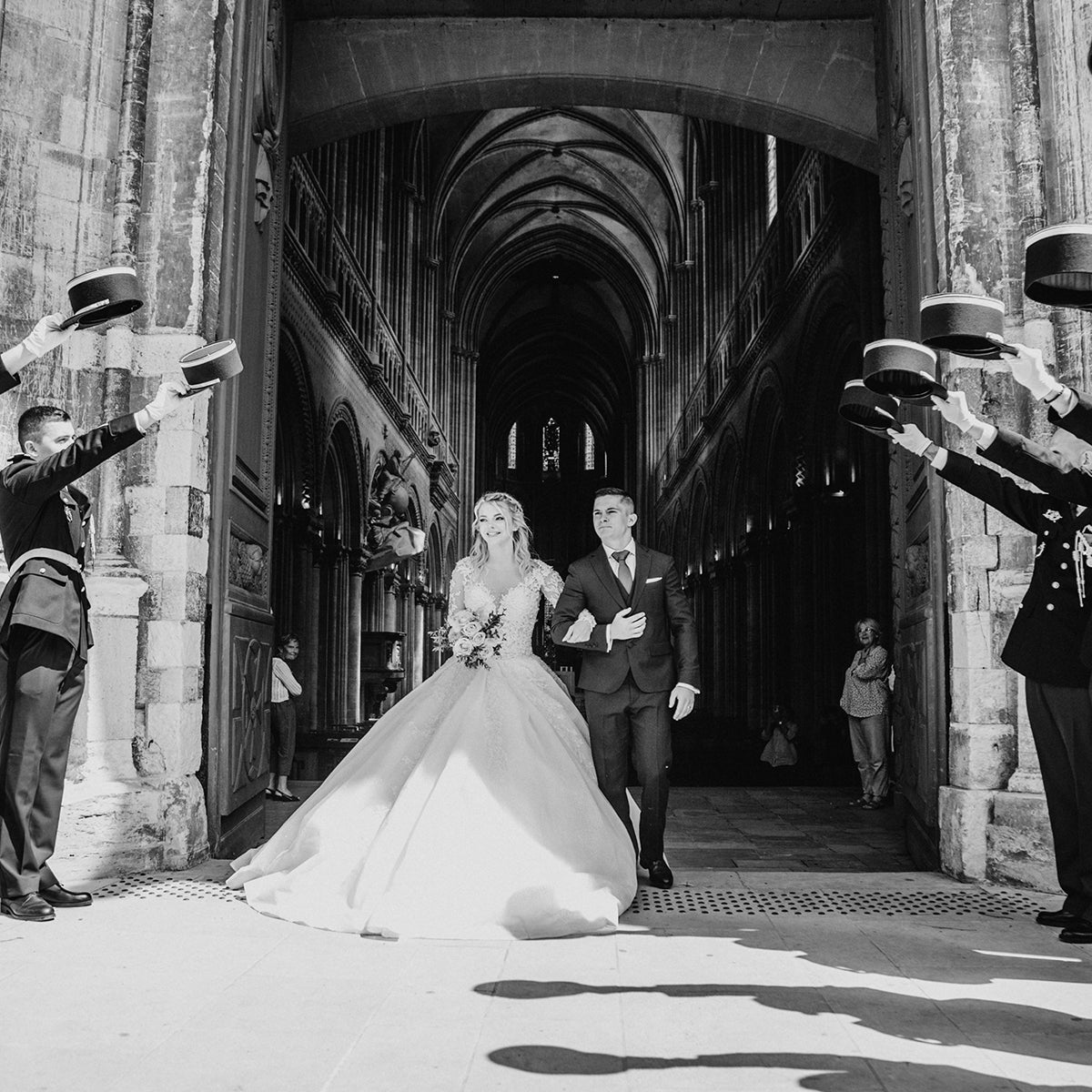 Mariée en robe princesse Autour du Mariage sortant de l’église avec le marié, cérémonie en noir et blanc