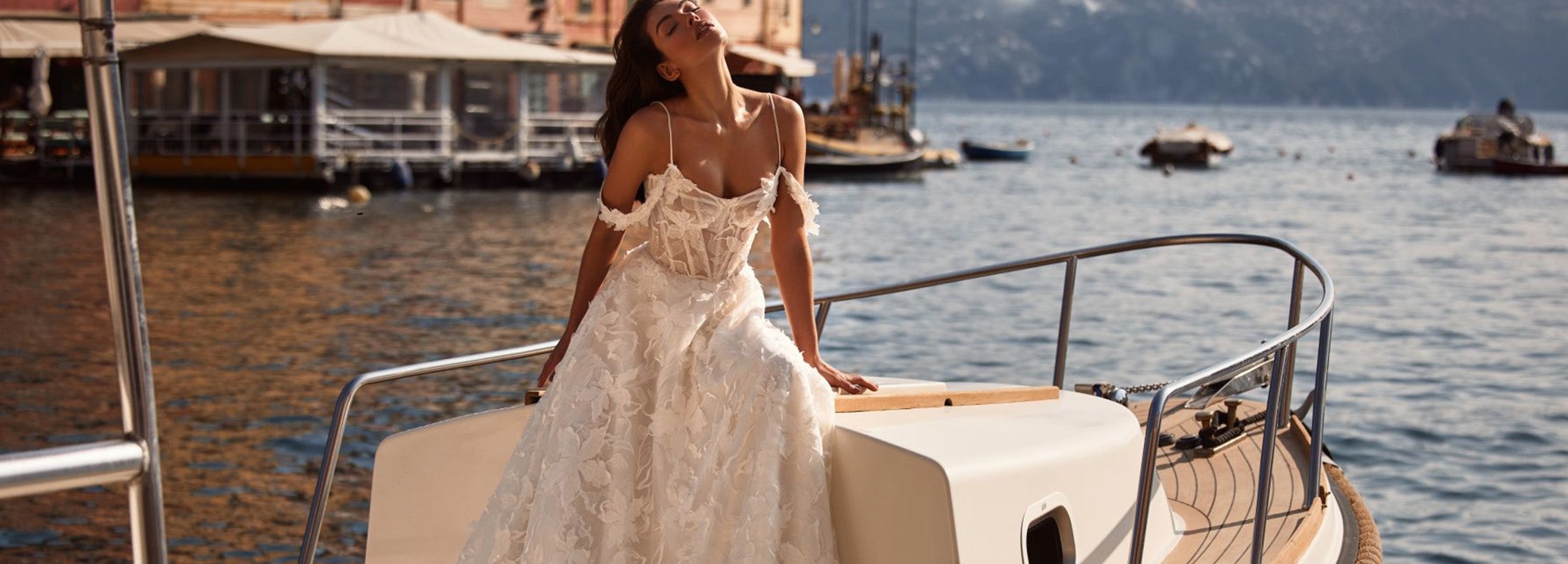 Robe de mariée en dentelle avec corsage semi-transparent, bretelles fines et épaules tombantes, jupe fluide et volumineuse élégante.